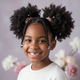 Smiling young Black girl with styled natural hair, looking happy and confident.